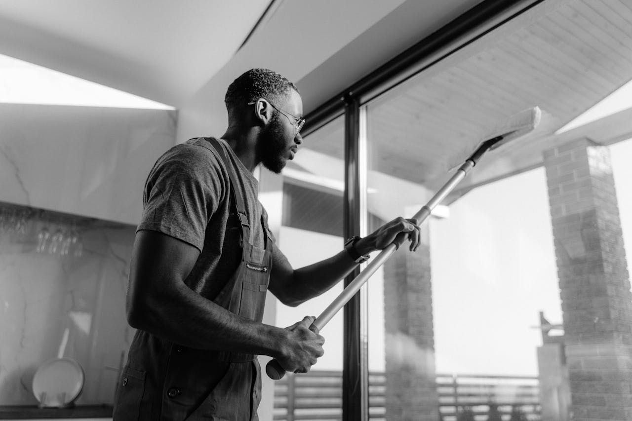 Mastering the First Impression: Your intriguing post title goes here A professional cleaner wiping large glass panels with precision inside a modern building.